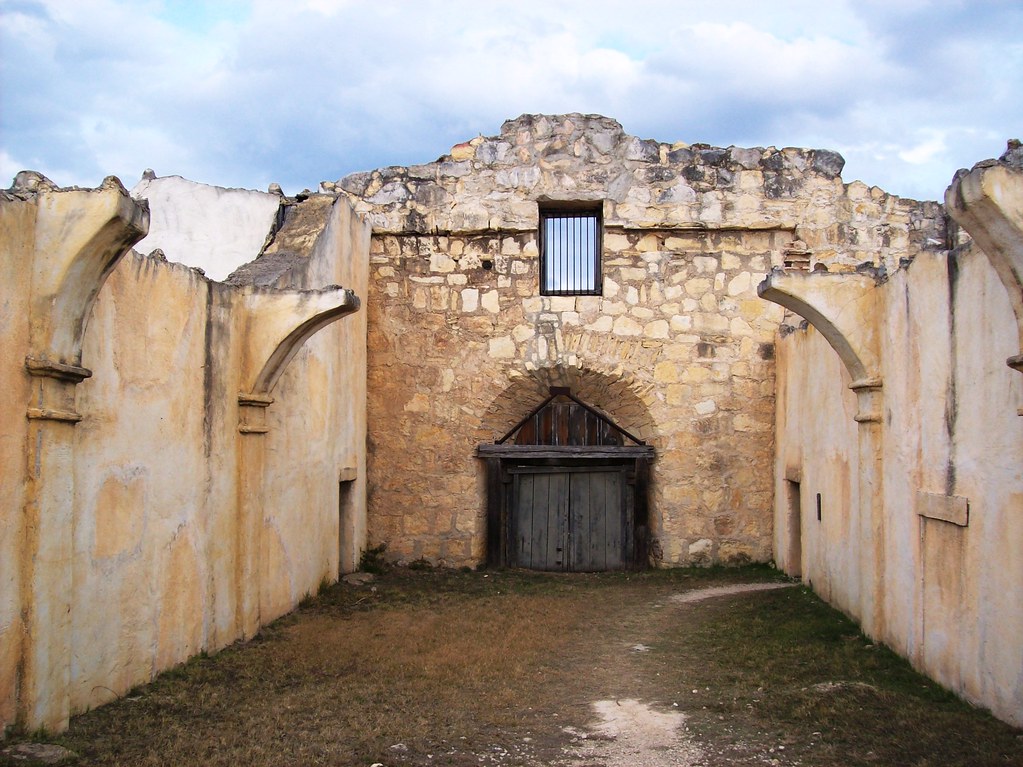 abandoned stone structure with an archway leading to a door